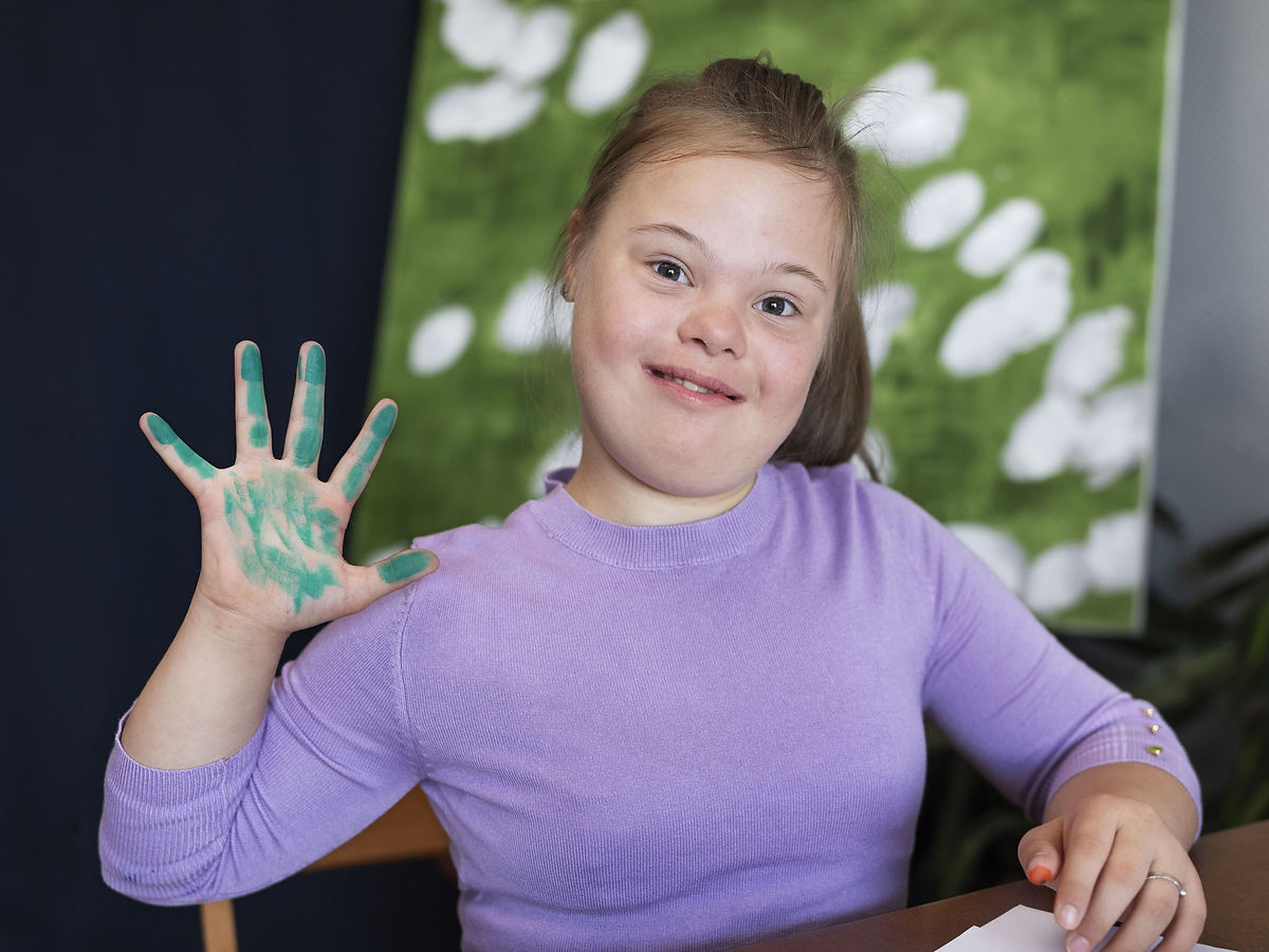 Participant painting, engaged and smiling